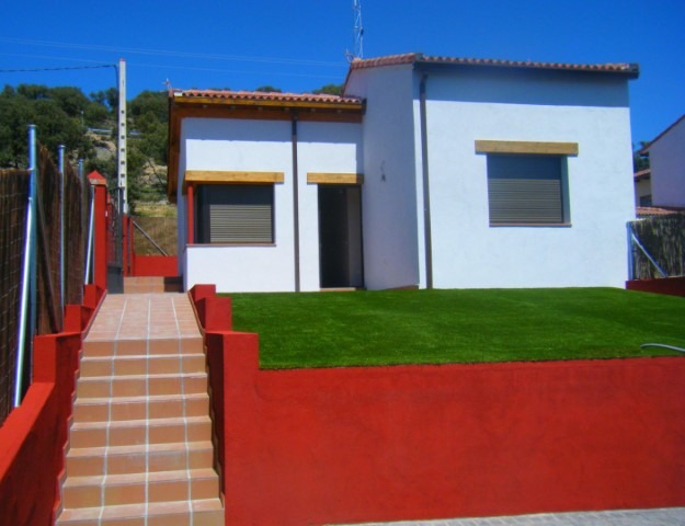 Casa muy bien pintada con colores en blanco y amarillo, y además, una escalera cuyos laterales y frontal están pintados en rojo