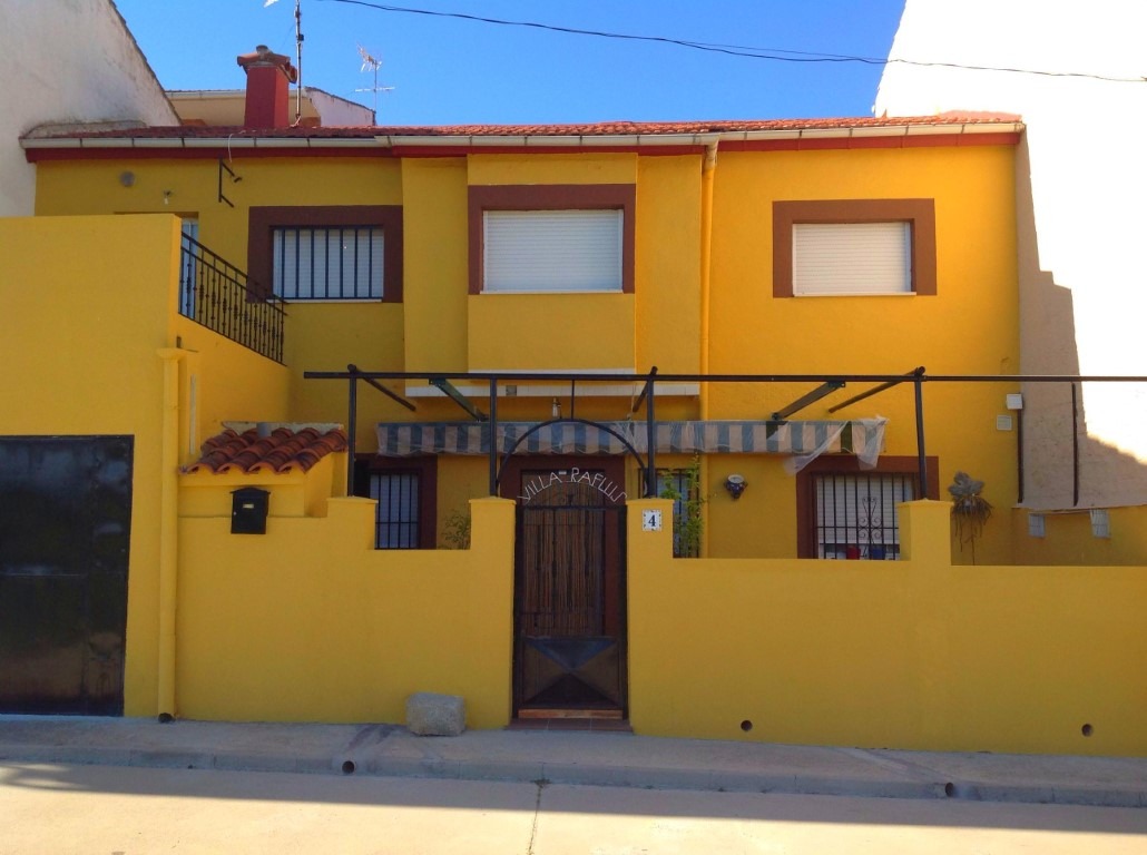 Fachada de una casa pintada de color amarillo oscuro